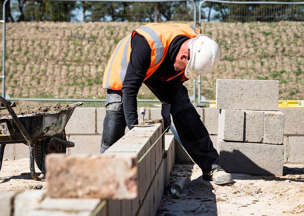 Choosing The Right Concrete Companies In Burlington North Carolina A Civilian Contractor Places Cement Bricks In Line 55931e 1024